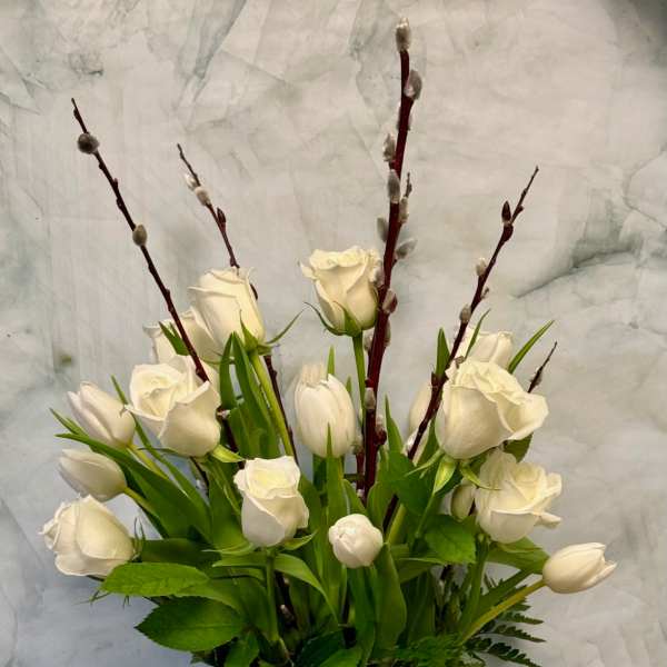 White tulips and roses in a clear glass vase