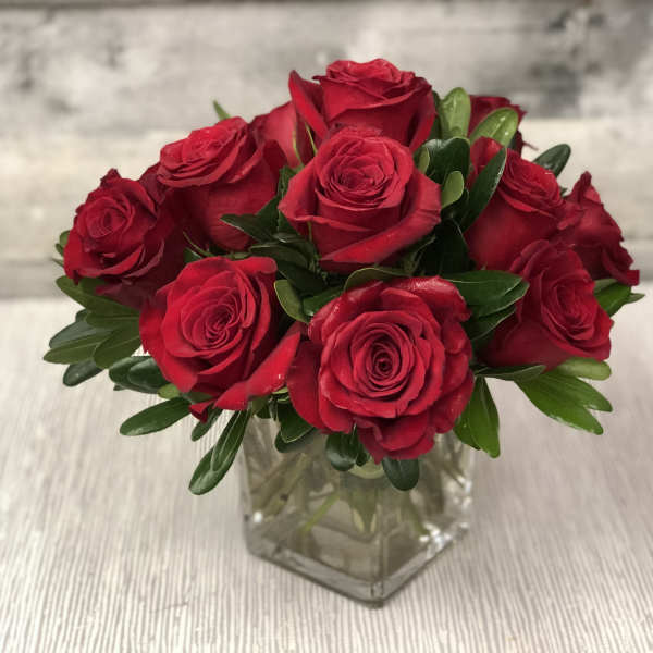 Red roses arranged in a clear glass vase