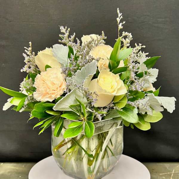 Cream and peach floral arrangement in a clear glass vase