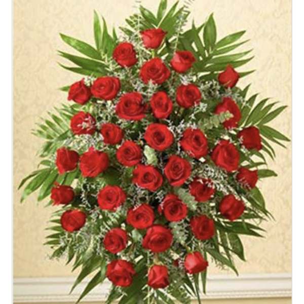 Standing spray of red roses with greenery