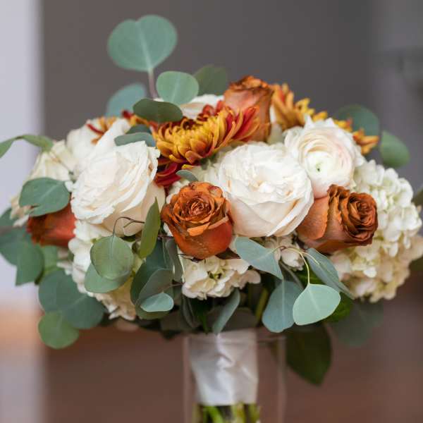 Bouquet of white and orange roses in a clear glass vase