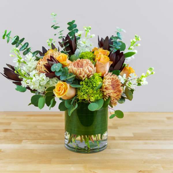 Bouquet of peach roses and chrysanthemums in a glass vase