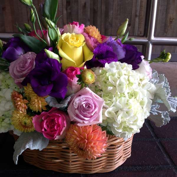 Colorful mixed flower arrangement in a wicker basket