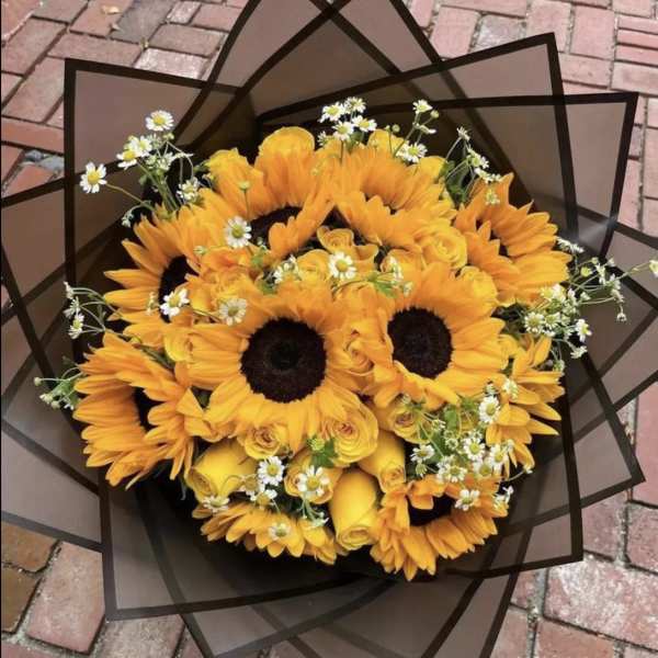 Bouquet of sunflowers and yellow roses with small white daisies