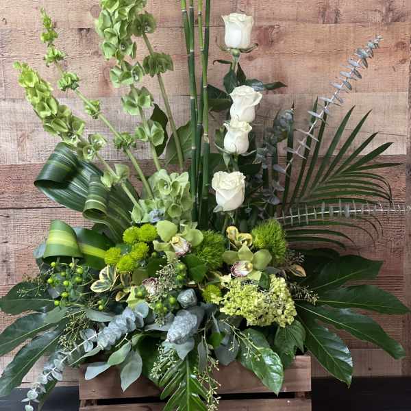 Tall green floral arrangement with white roses in a wooden box