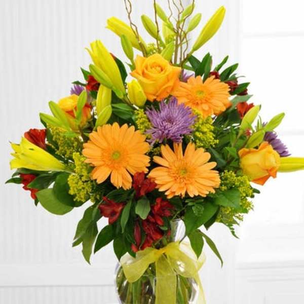 Bouquet of orange and yellow flowers in a clear glass vase