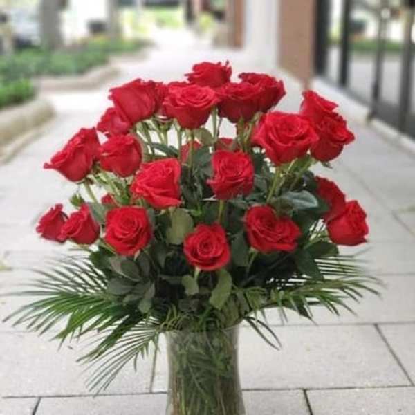 Red roses arranged in a clear glass vase