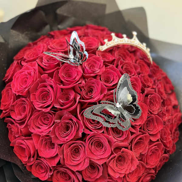 Round bouquet of red roses with butterfly decorations