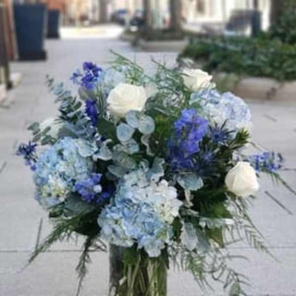 Blue and white floral arrangement in a clear glass vase