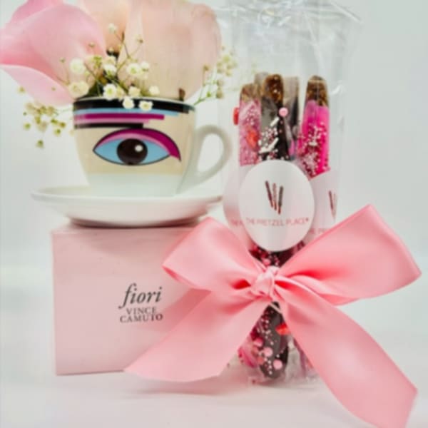 Pink petals in a decorative cup beside a wrapped gift with a bow