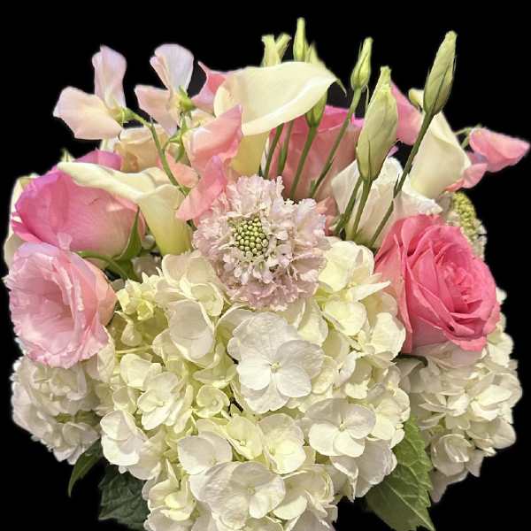 Pink and white bouquet in a glass vase with a pink ribbon
