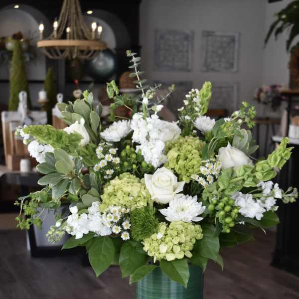 White and green floral arrangement in a glass vase