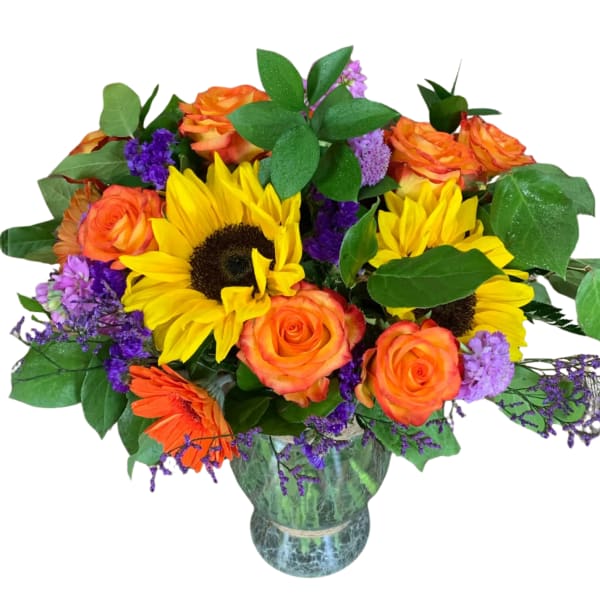 Bouquet of sunflowers, orange roses, and purple filler in a glass vase