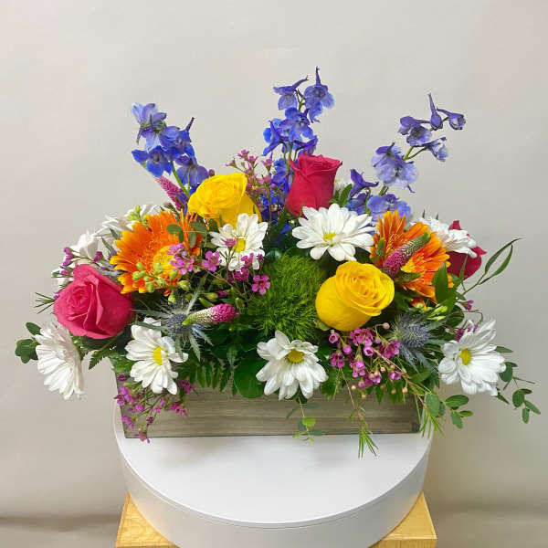 Colorful mixed flower arrangement in a rectangular wooden box