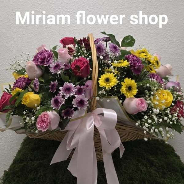 Basket arrangement of pink, purple, yellow, and red flowers with a pink ribbon