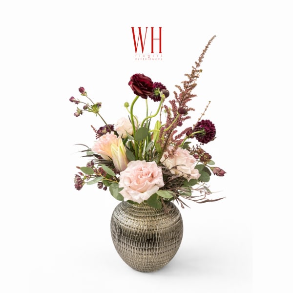 Pink and burgundy floral arrangement in a textured metallic vase