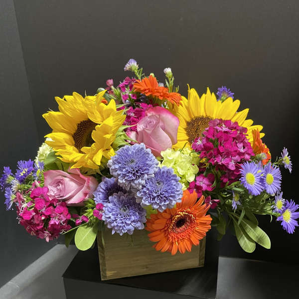 Colorful mixed bouquet with sunflowers, roses, and gerbera daisies in a box
