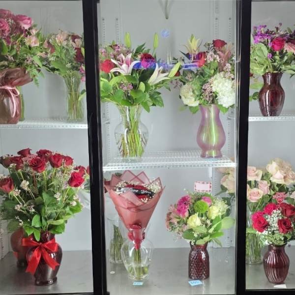 Assorted flower bouquets arranged in vases on display shelves
