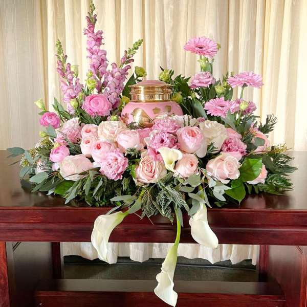 Pink floral casket spray with roses, lilies, and calla lilies