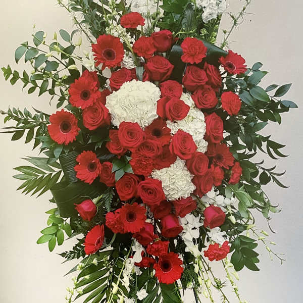 Large standing floral spray with red roses, red gerbera daisies, and white blooms