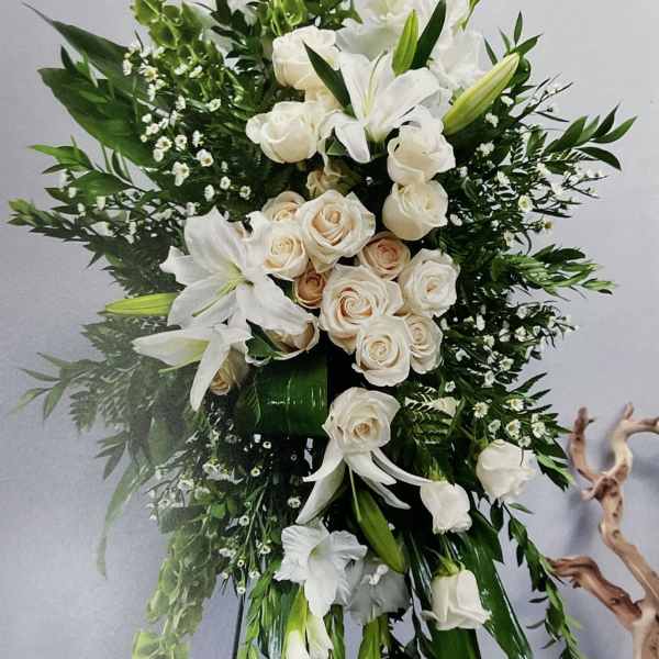 Tall white floral spray with roses and lilies on a stand