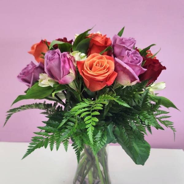 Bouquet of multicolored roses in a clear glass vase