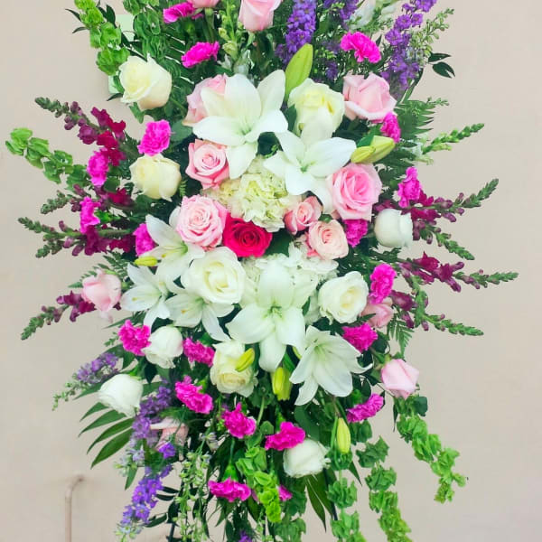 Tall standing floral spray with pink roses, white lilies, and purple spikes