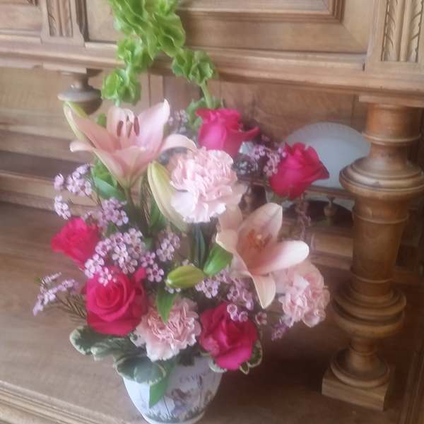 Pink and white floral arrangement in a decorative vase