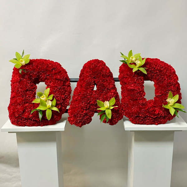 Red floral letters spelling DAD with green orchid accents