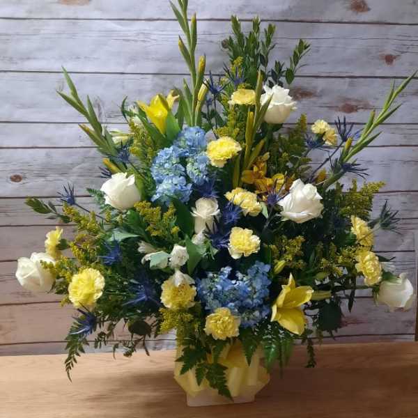 Mixed bouquet with blue hydrangeas, white roses, and yellow lilies in a vase