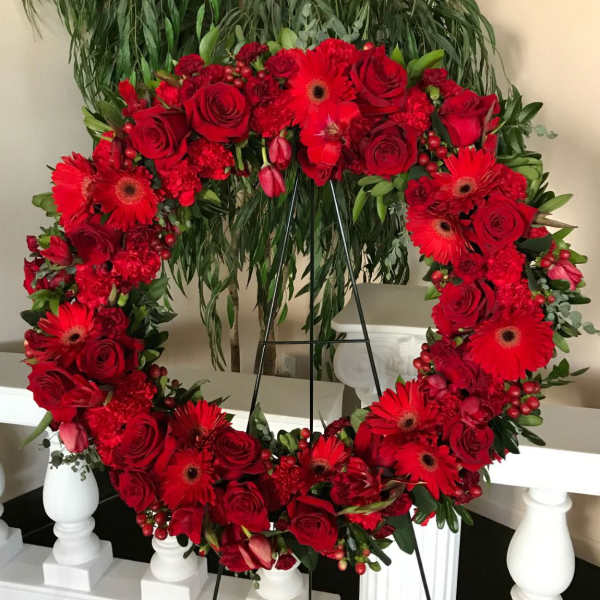 Heart-shaped red floral wreath on a stand