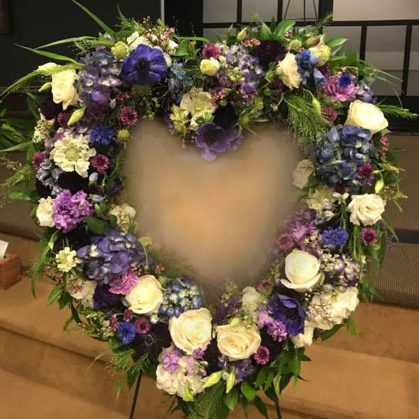 Heart-shaped floral wreath with purple, white, and blue flowers