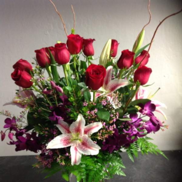 Red roses and pink lilies in a clear glass vase