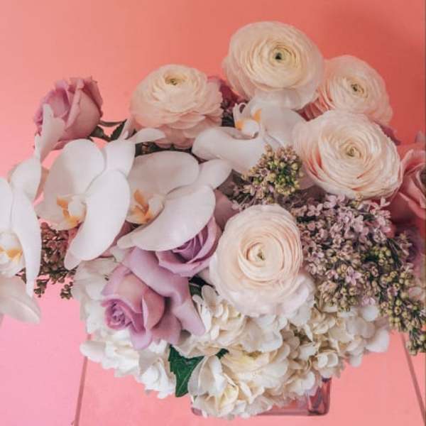 Bouquet of pale pink and white flowers in a clear vase