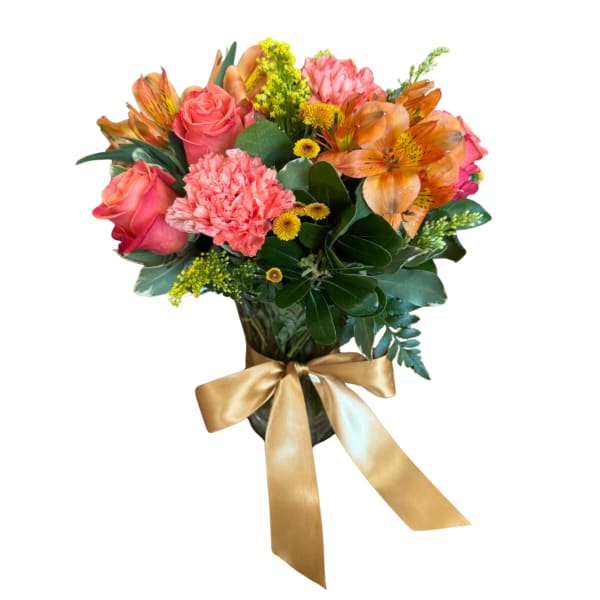 Bouquet of pink roses, carnations, and orange alstroemeria in a vase with a gold ribbon