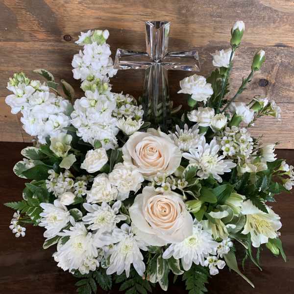 White floral arrangement with a silver cross centerpiece