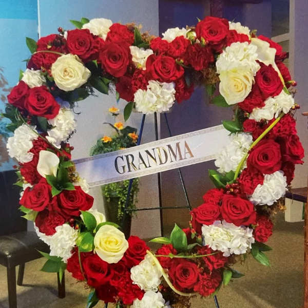 Heart-shaped floral wreath of red and white roses with a GRANDMA sign