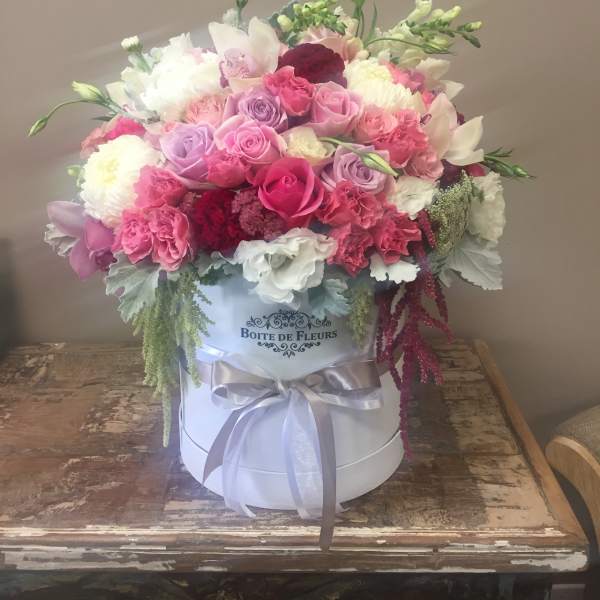 Pink and white mixed flower arrangement in a white hat box with ribbon
