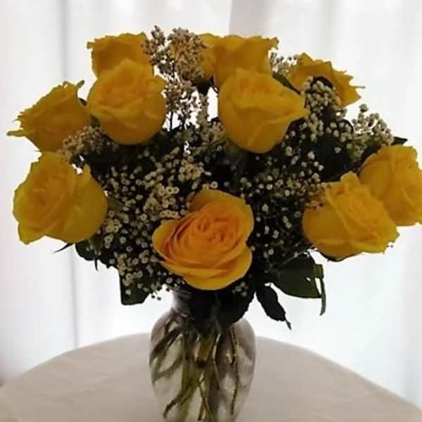 Yellow roses arranged in a clear glass vase