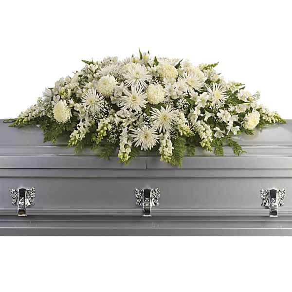 White floral casket spray on a gray casket