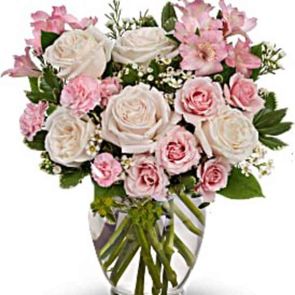Pink and white roses arranged in a clear glass vase