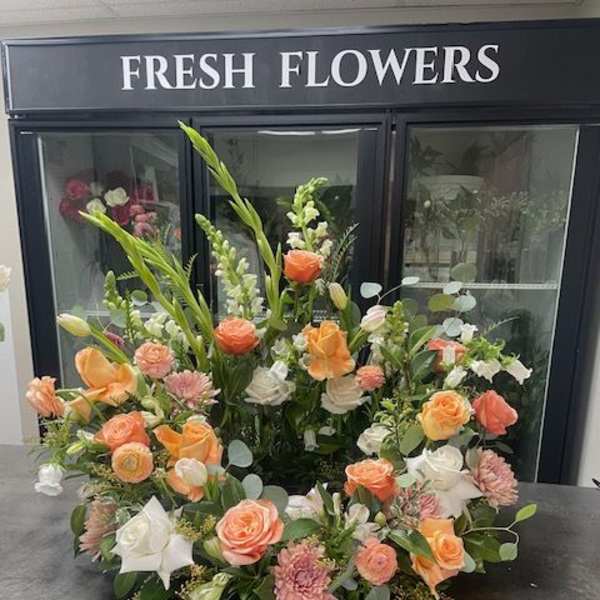 Large floral arrangement with peach, white, and pink blooms