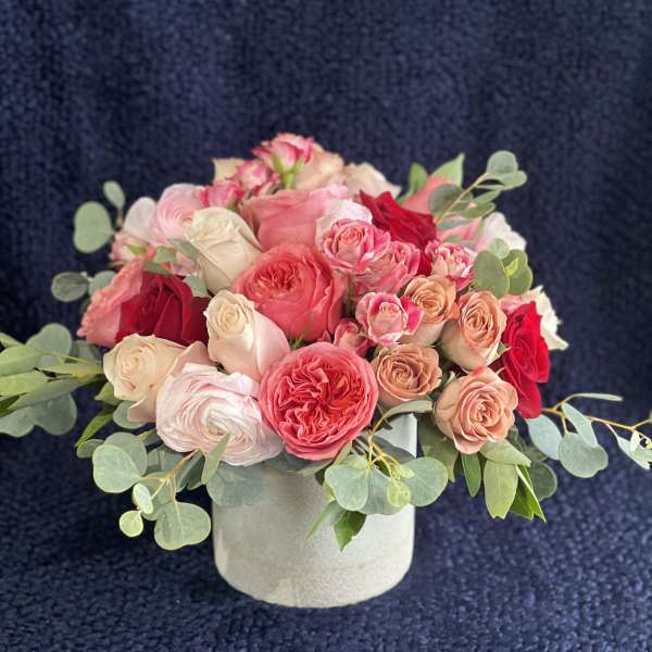 Pink and red rose arrangement in a white round vase