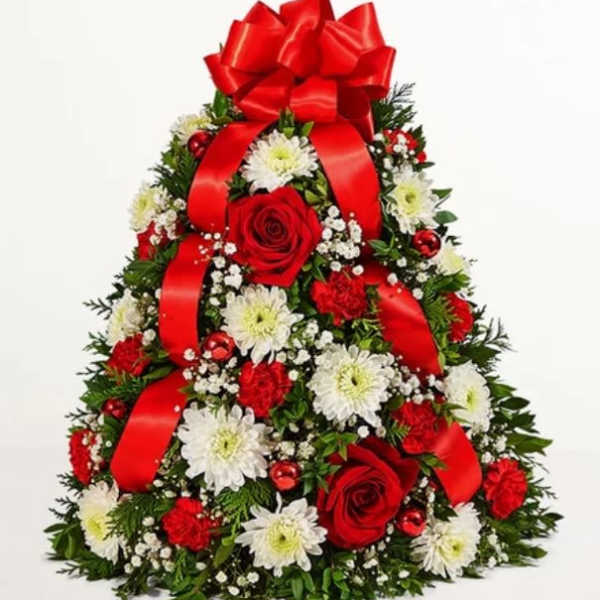 Christmas tree-shaped floral arrangement with red roses, white daisies, and a red bow