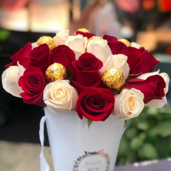 Red and white roses in a white cone box with gold chocolates