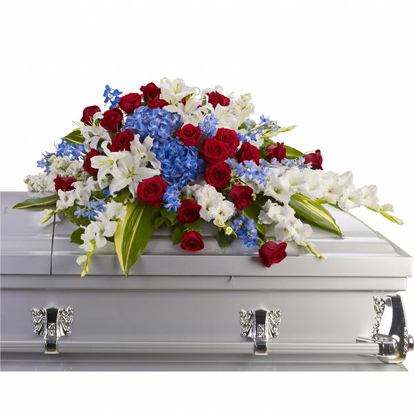 Red, white, and blue floral spray on a silver casket