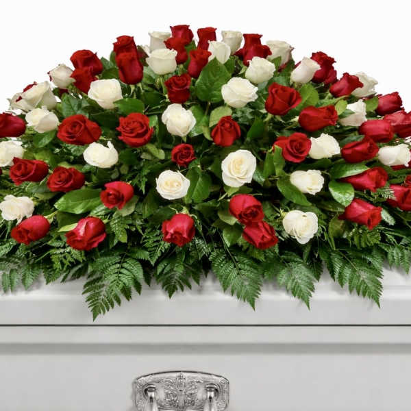 Red and white roses arranged on a white casket