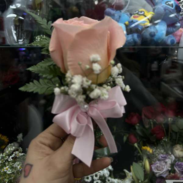 Single peach rose boutonniere with baby's breath and pink ribbon