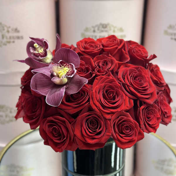 Red roses with two purple orchids in a black vase