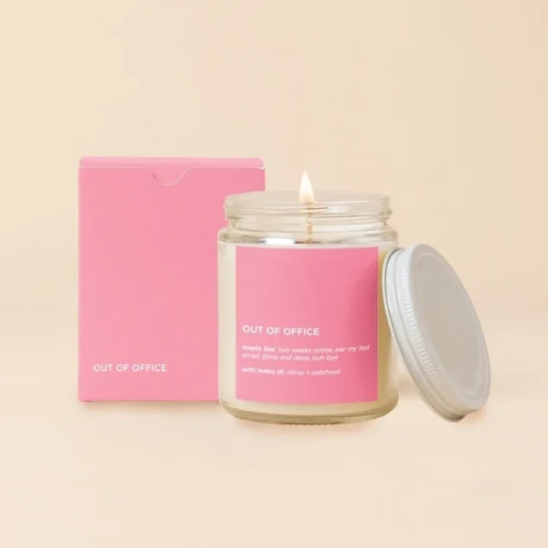 Lit candle in a glass jar with a pink box and lid